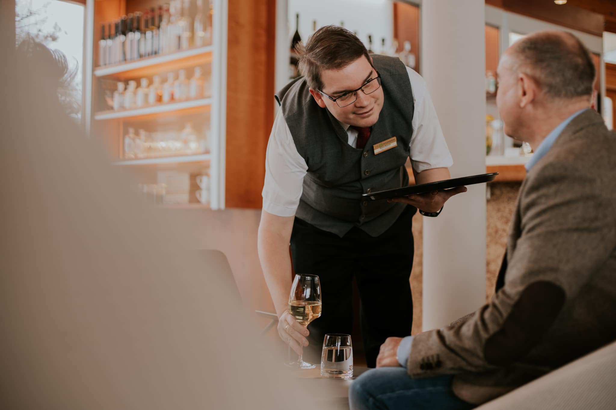 Balazs-Service_WASNERIN Service-Mitarbeiter serviert ein Glas Wein