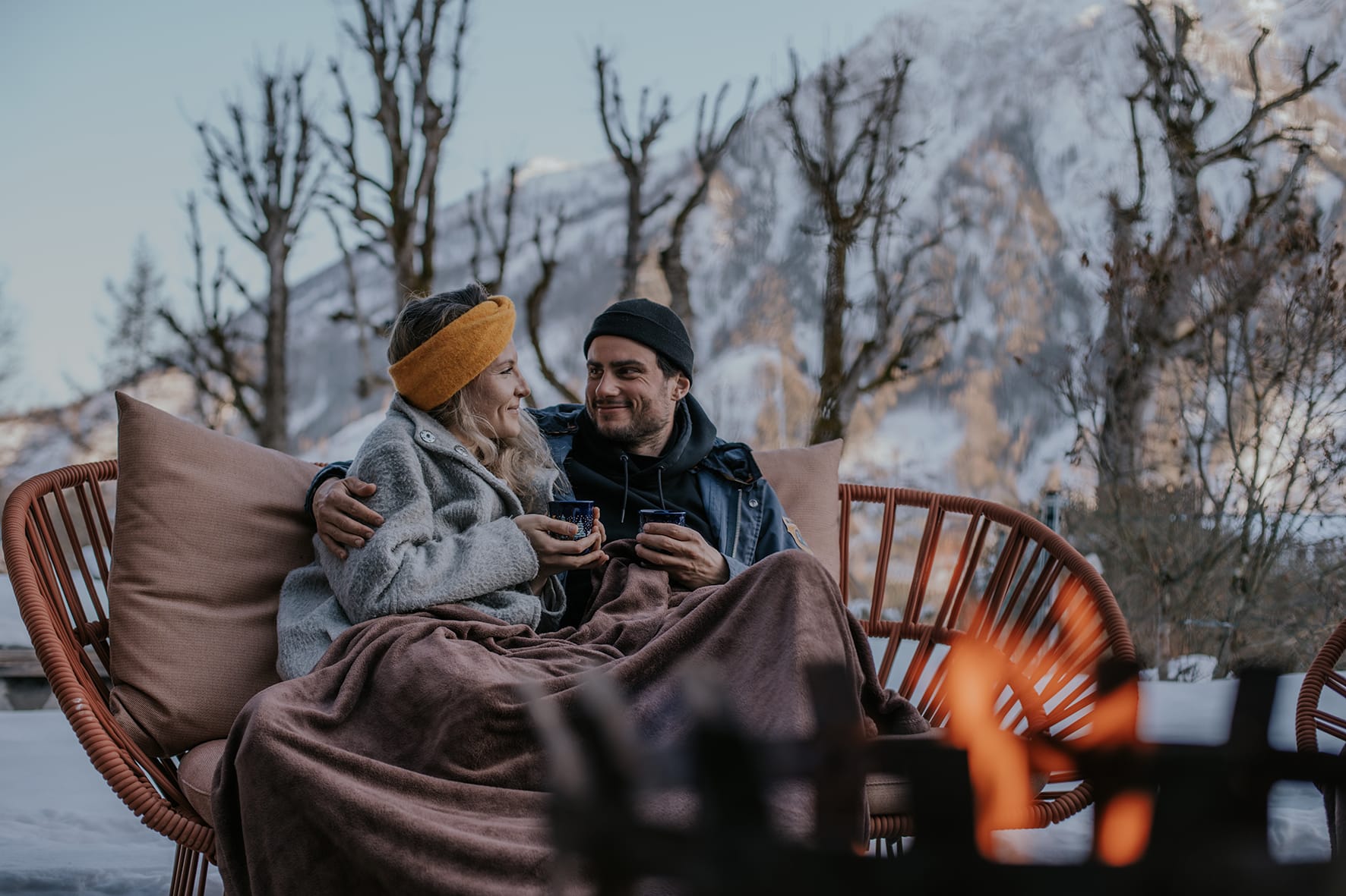 Kastanienterrasse Winter klein_DIE WASNERIN_tinksi Pärchen eingekuschelt mit Teetasse auf Lounge im Freien